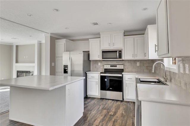 kitchen with dark wood-type flooring, white cabinetry, a center island, and stainless steel appliances