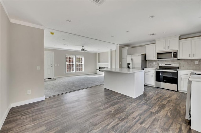 kitchen featuring dark hardwood / wood-style floors, a kitchen island, white cabinetry, and appliances with stainless steel finishes