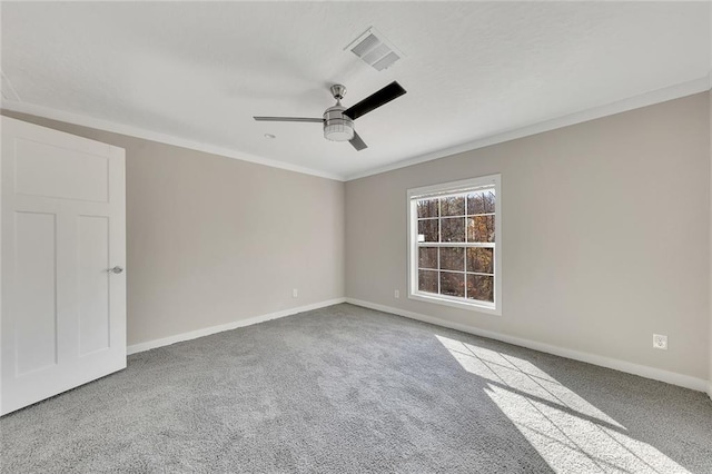 carpeted spare room with ceiling fan and ornamental molding