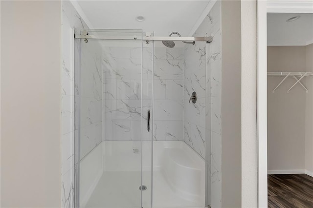 bathroom with wood-type flooring and a shower with shower door