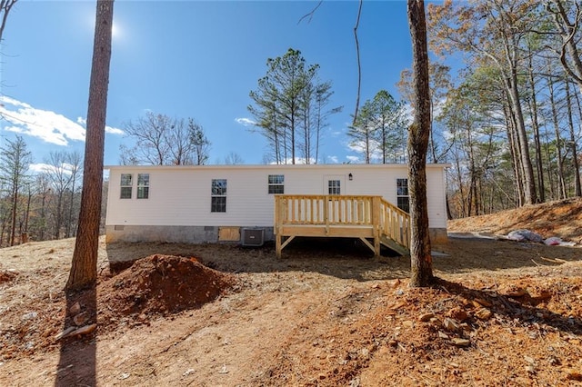 rear view of property with central air condition unit and a wooden deck