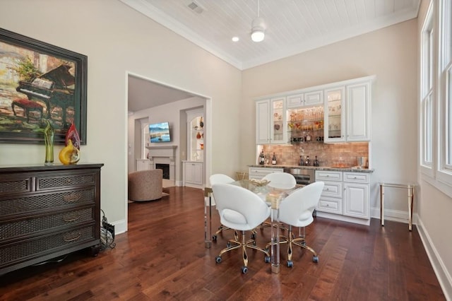 dining space featuring dark wood-type flooring and crown molding