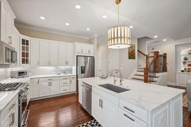 kitchen featuring white cabinets, hanging light fixtures, dark hardwood / wood-style flooring, appliances with stainless steel finishes, and sink