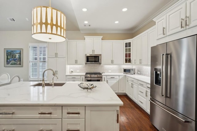 kitchen with sink, light stone counters, decorative light fixtures, crown molding, and high end appliances