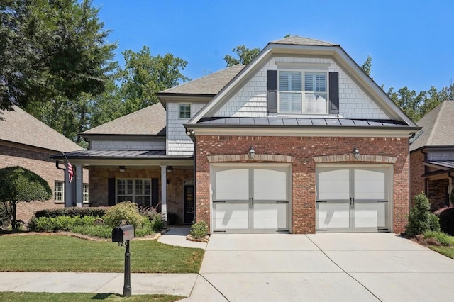 view of front of property with a garage, covered porch, and a front yard