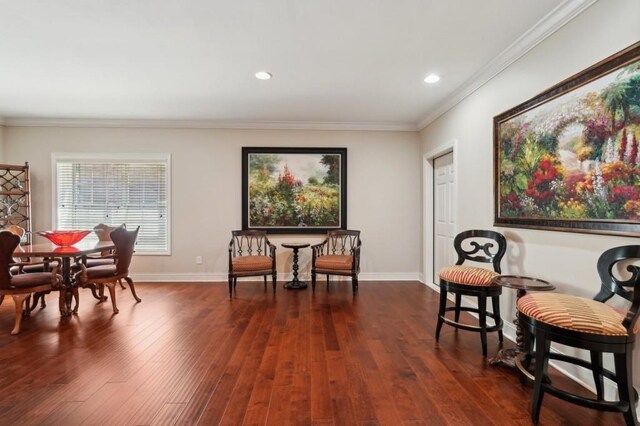 living area with dark wood-type flooring and ornamental molding