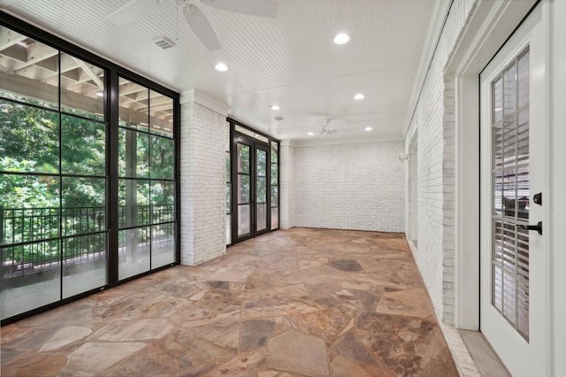 hallway with brick wall, french doors, and crown molding