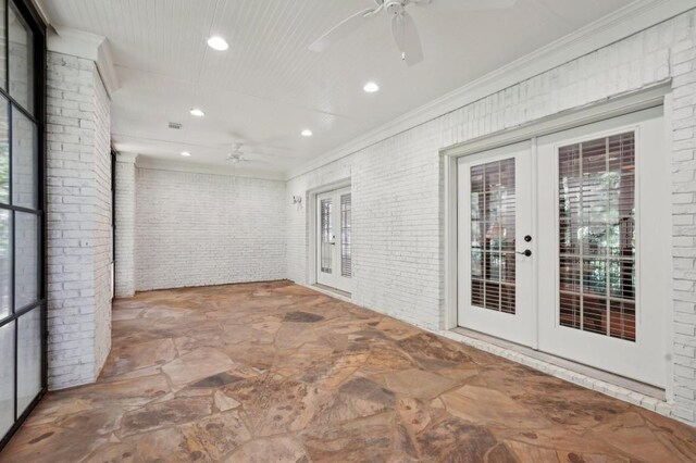 unfurnished room with brick wall, french doors, crown molding, and ceiling fan