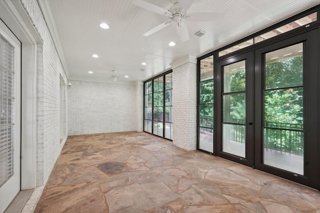 interior space with french doors, brick wall, and ceiling fan