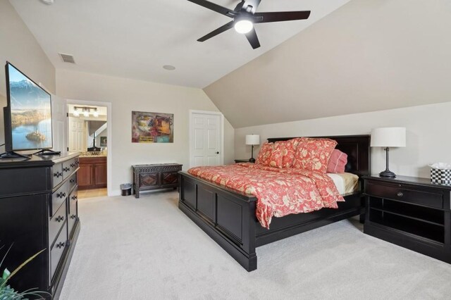 bedroom with light carpet, lofted ceiling, ensuite bathroom, and ceiling fan