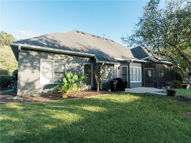 back of property featuring a lawn and a sunroom