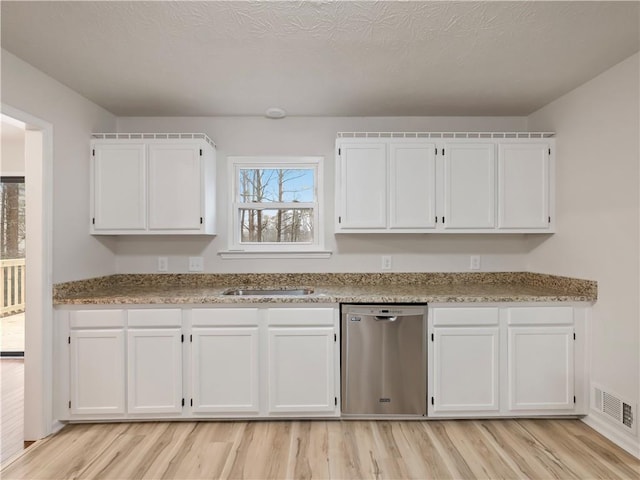 kitchen featuring sink, dishwasher, light stone countertops, white cabinets, and light wood-type flooring