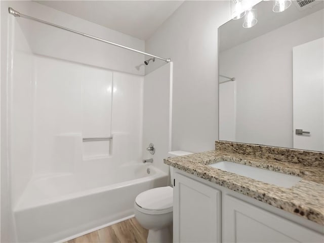 full bathroom featuring wood-type flooring, toilet, tub / shower combination, and vanity