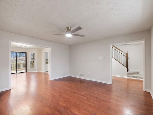 unfurnished room with ceiling fan, dark hardwood / wood-style floors, and a textured ceiling