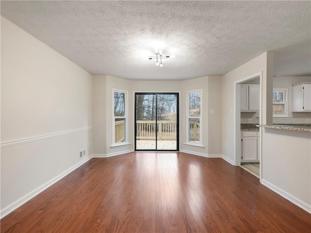 unfurnished living room with hardwood / wood-style flooring and a textured ceiling