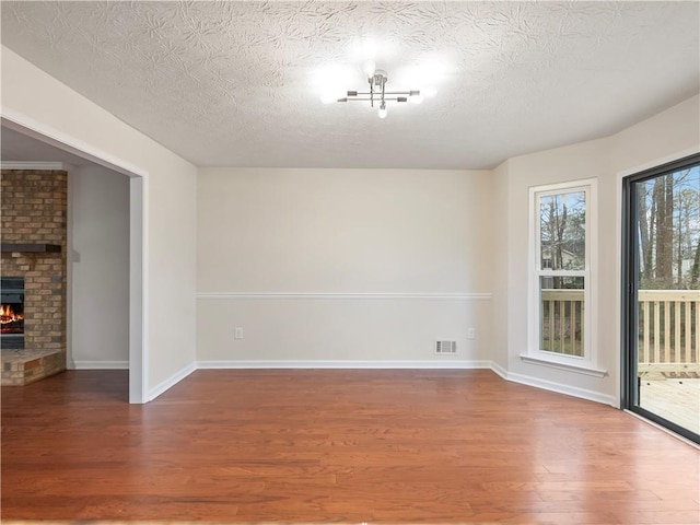 interior space with wood-type flooring, a textured ceiling, and a fireplace