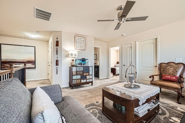 living area featuring visible vents, baseboards, light colored carpet, and attic access