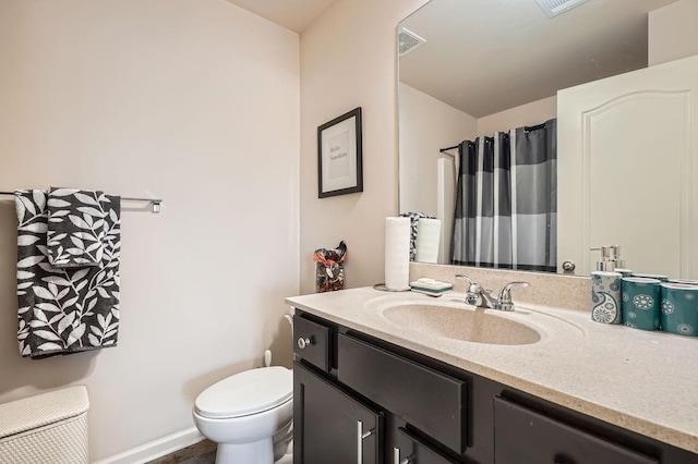 bathroom with vanity, a shower with shower curtain, baseboards, visible vents, and toilet