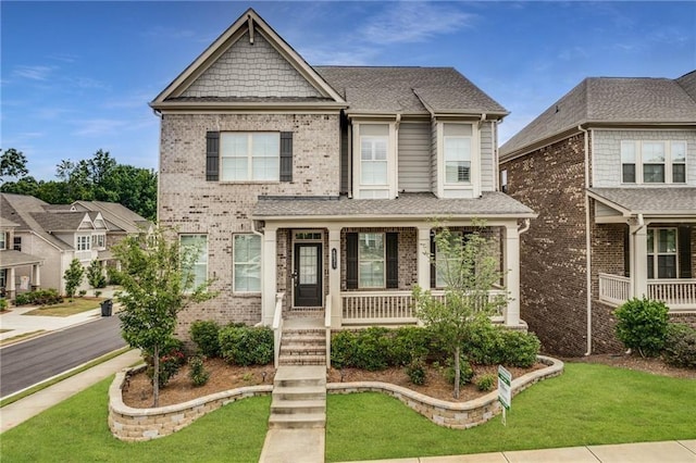4831 Miller Hill Rd, Buford, GA 30518 - view of front of house with covered porch, brick siding, a front yard, and a shingled roof