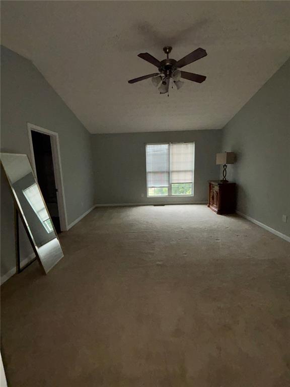 6231 Redan Overlook, Lithonia, GA 30058 - unfurnished living room with lofted ceiling, a ceiling fan, carpet, and baseboards