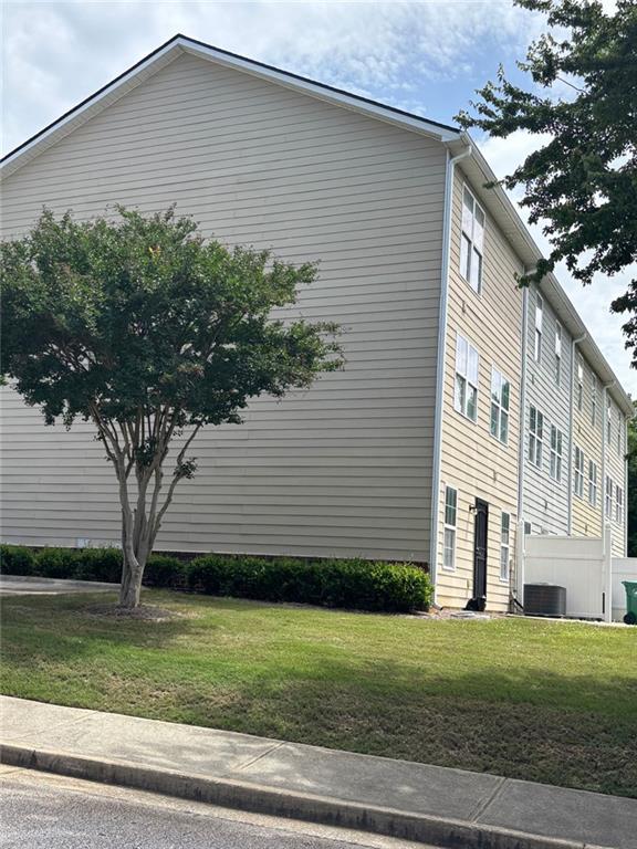 6231 Redan Overlook, Lithonia, GA 30058 - view of home's exterior with a lawn and central AC