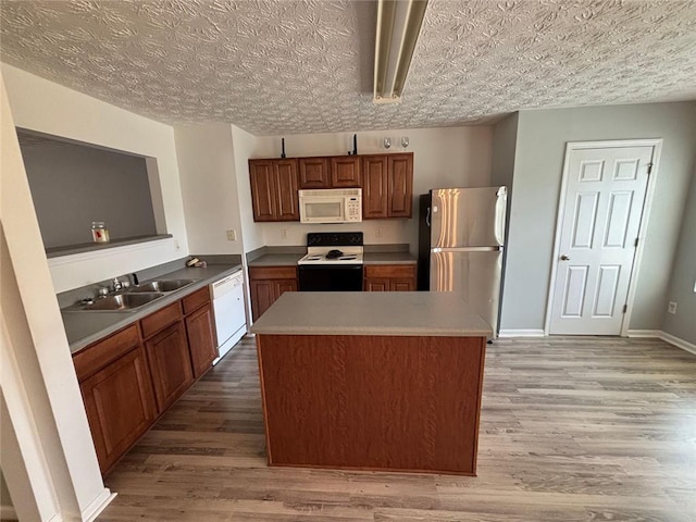 6231 Redan Overlook, Lithonia, GA 30058 - kitchen featuring white appliances, a sink, light wood-style floors, and a center island