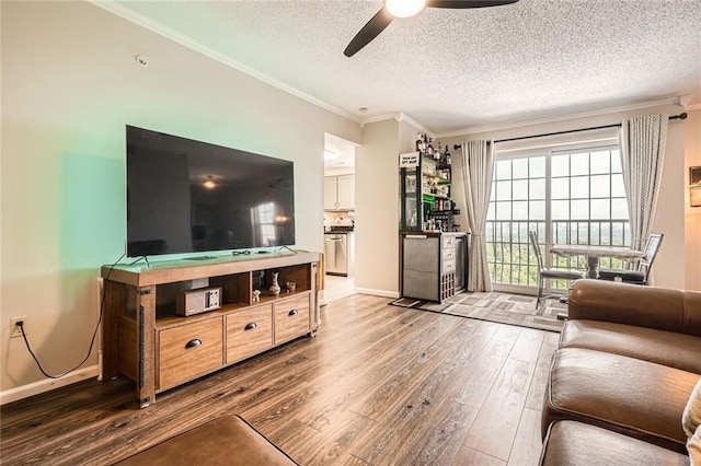 living room featuring a textured ceiling, ceiling fan, ornamental molding, and hardwood / wood-style floors