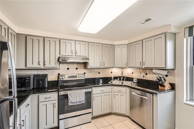 kitchen with visible vents, under cabinet range hood, a sink, appliances with stainless steel finishes, and gray cabinetry