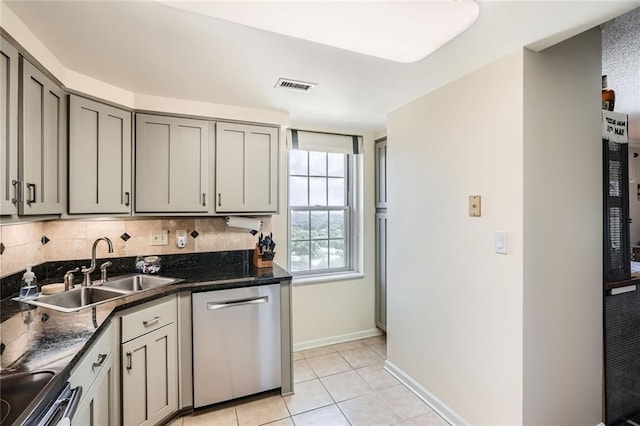 kitchen with gray cabinets, visible vents, appliances with stainless steel finishes, dark countertops, and a sink