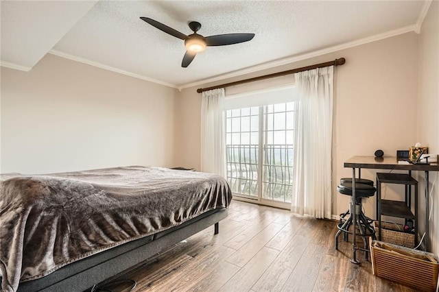 bedroom featuring ceiling fan, a textured ceiling, access to exterior, crown molding, and wood finished floors