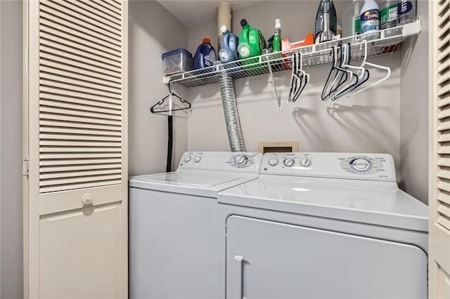 laundry room featuring laundry area, a textured ceiling, and washer and clothes dryer