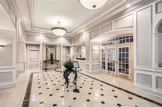 entryway featuring a high ceiling, a decorative wall, french doors, recessed lighting, and ornamental molding