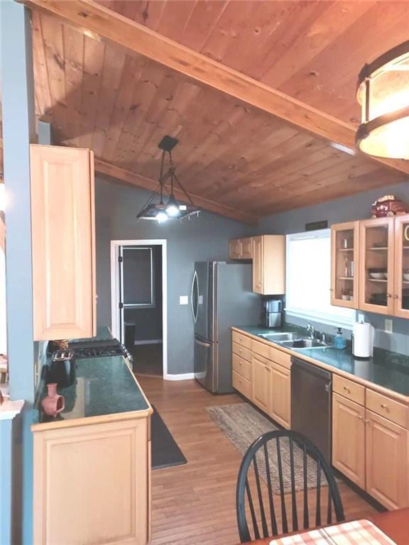 kitchen featuring appliances with stainless steel finishes, light wood-style floors, vaulted ceiling, a sink, and wooden ceiling