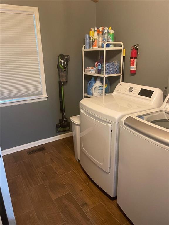 laundry area with wood finish floors, visible vents, laundry area, independent washer and dryer, and baseboards