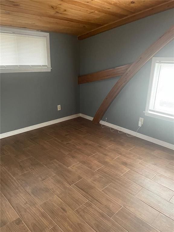 spare room featuring wooden ceiling, wood finished floors, and baseboards