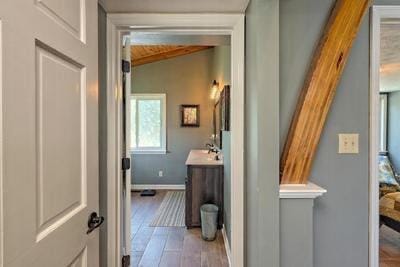 bathroom featuring vaulted ceiling, wood finished floors, vanity, and baseboards