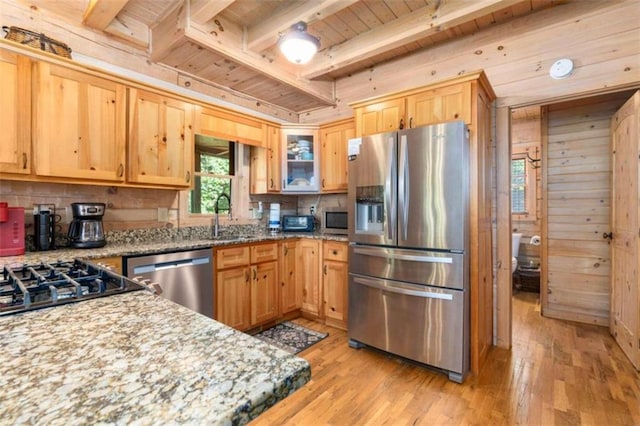 kitchen with beamed ceiling, wood ceiling, light hardwood / wood-style flooring, light stone counters, and appliances with stainless steel finishes