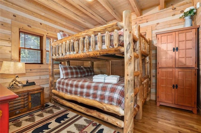 bedroom with wood ceiling, wooden walls, light hardwood / wood-style floors, and beamed ceiling