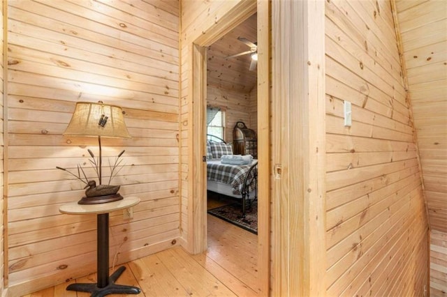 hallway with wood walls and light hardwood / wood-style flooring