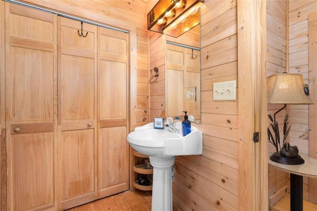 bathroom featuring wood walls and hardwood / wood-style flooring