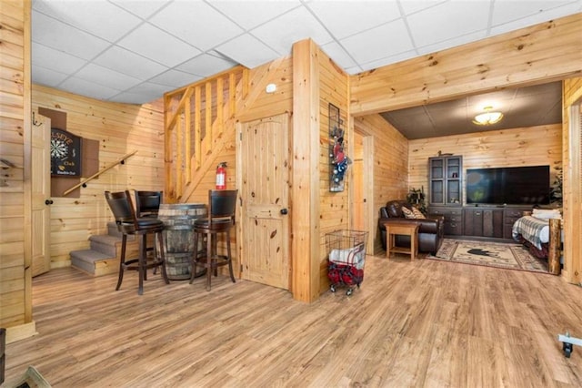 interior space featuring hardwood / wood-style flooring, wood walls, and a paneled ceiling