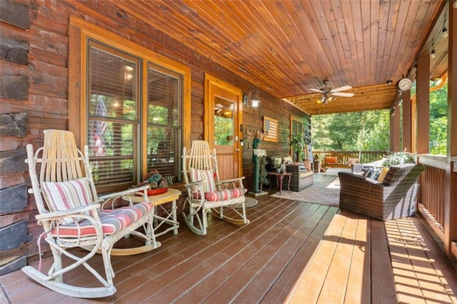 wooden terrace featuring ceiling fan and an outdoor living space