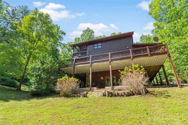 rear view of house with a lawn and a wooden deck