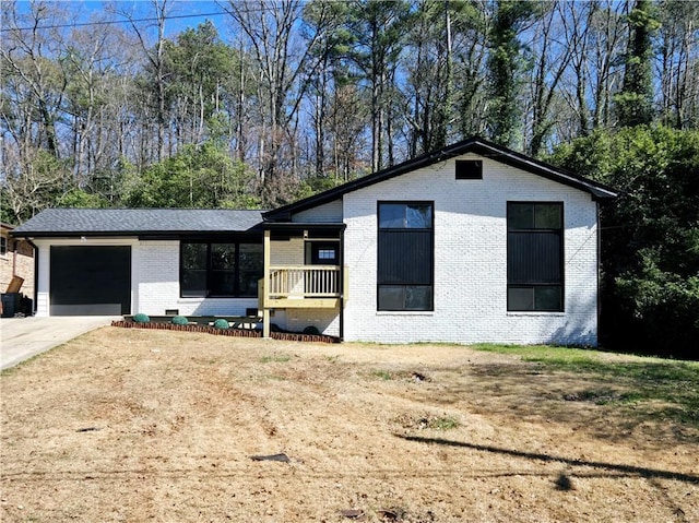 view of front of home featuring brick siding, concrete driveway, and a garage