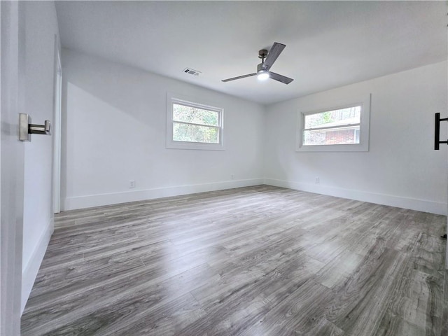 spare room featuring plenty of natural light, wood finished floors, and visible vents