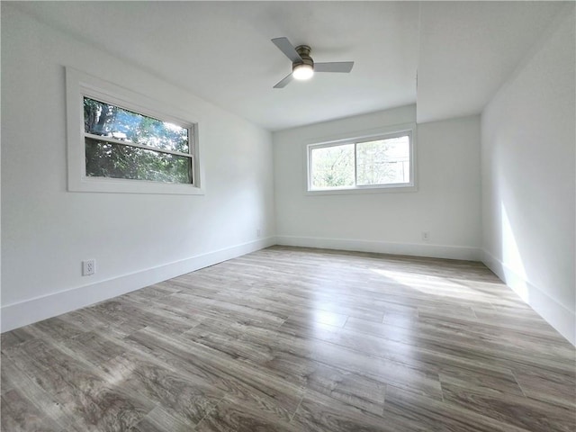 unfurnished room featuring a ceiling fan, baseboards, and wood finished floors