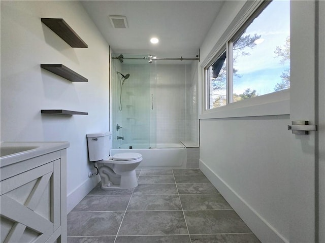 bathroom featuring tile patterned floors, visible vents, toilet, bath / shower combo with glass door, and vanity