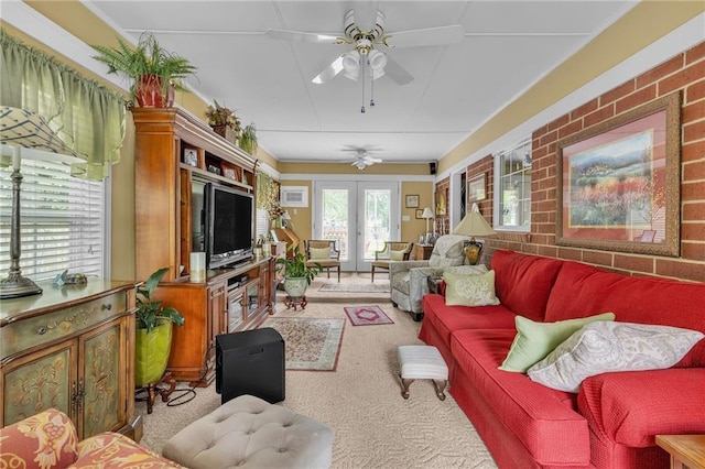 living room featuring carpet floors, a ceiling fan, brick wall, and french doors
