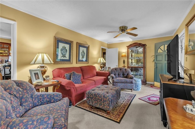 living room featuring ceiling fan, carpet, and ornamental molding