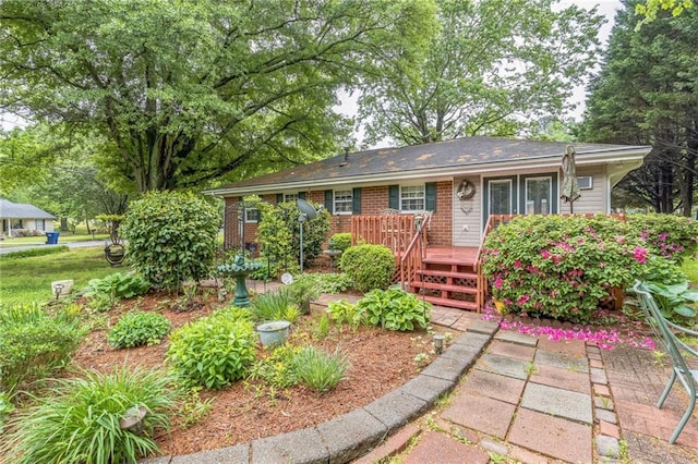 single story home with a deck and brick siding